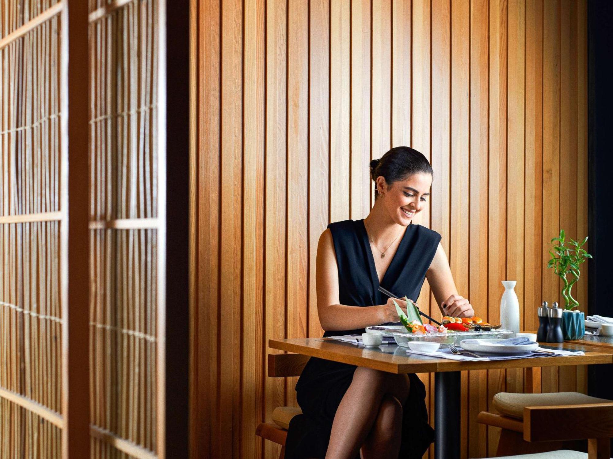 Fairmont Amman Hotel Kültér fotó A woman eating sushi