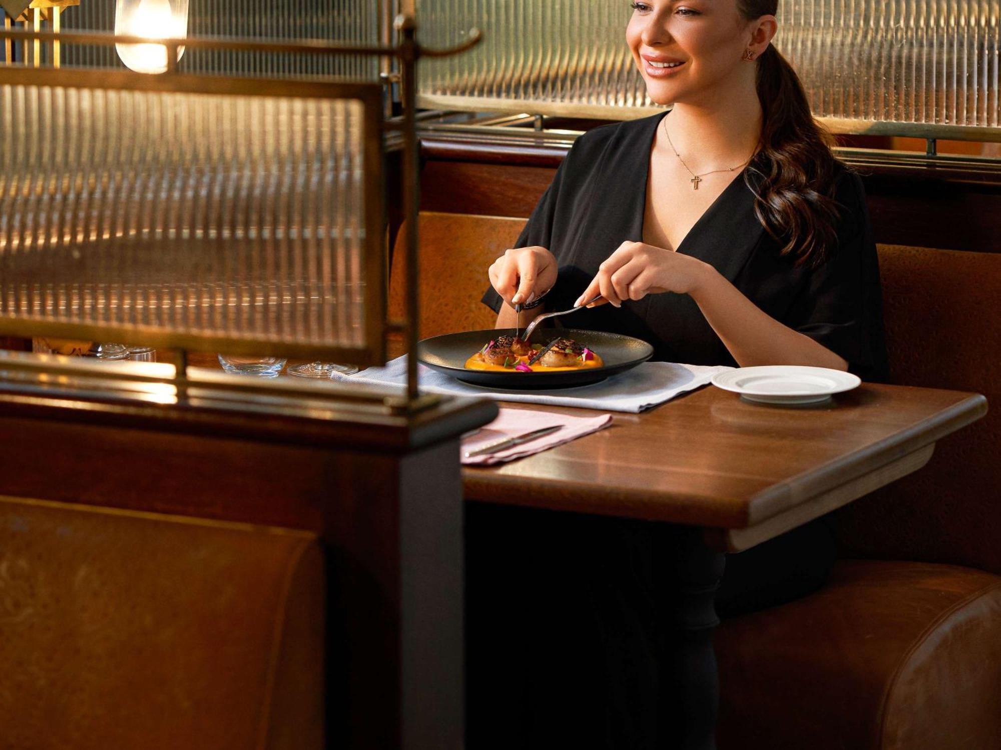 Fairmont Amman Hotel Kültér fotó A woman dining at a restaurant
