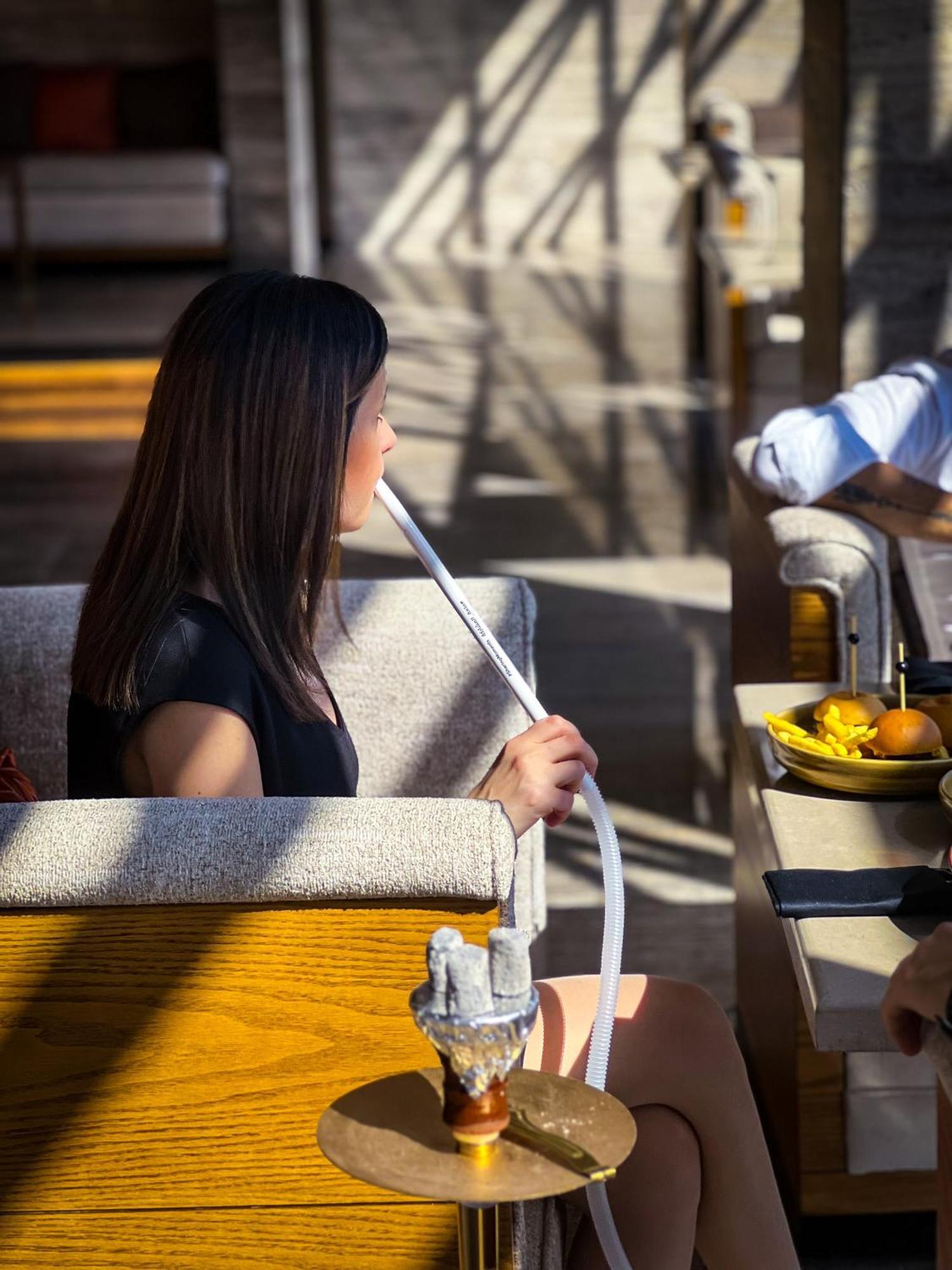 Fairmont Amman Hotel Kültér fotó A woman smoking a hookah
